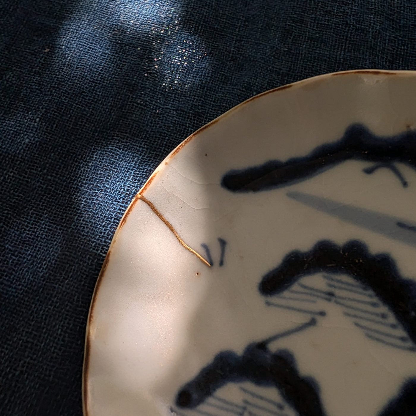 Close-up of a gold seam on an antique blue-and-white dish